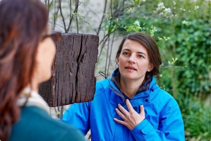 Ganzheitliche Betreuung durch Fachpersonen von SPITEX BASEL Spezialisierte Pflegefachperson im intensiven Gespräch mit einer jungen Frau draussen